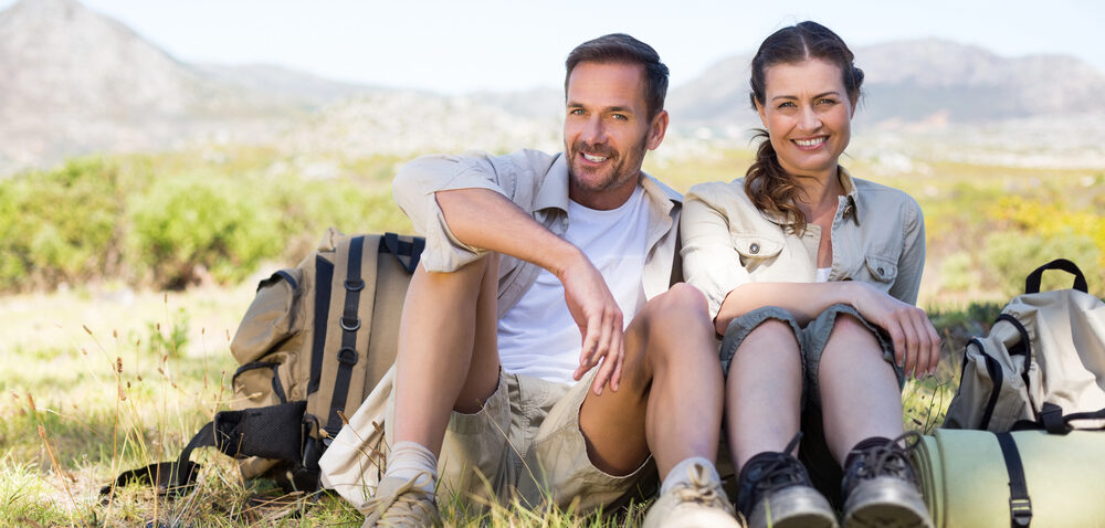 Man with full head of hair and vitality with healthy woman hiking photo for Bend Vitality Clinic.